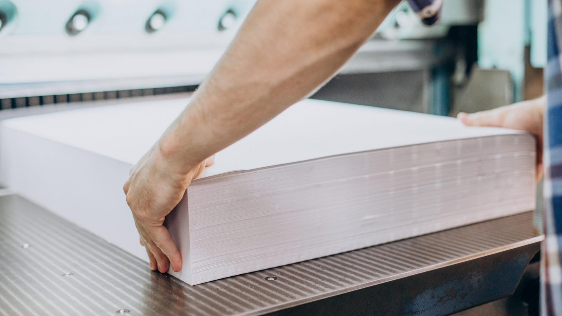 Man working in printing house with paper and paints